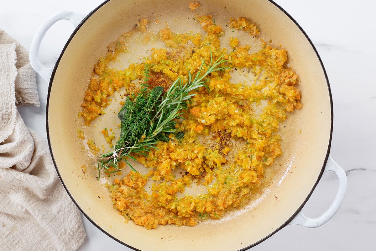 El sofrito de verduras cocinándose con el ramillete de hierbas.