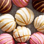 Conchas pan dulce displayed on a cooling rack.