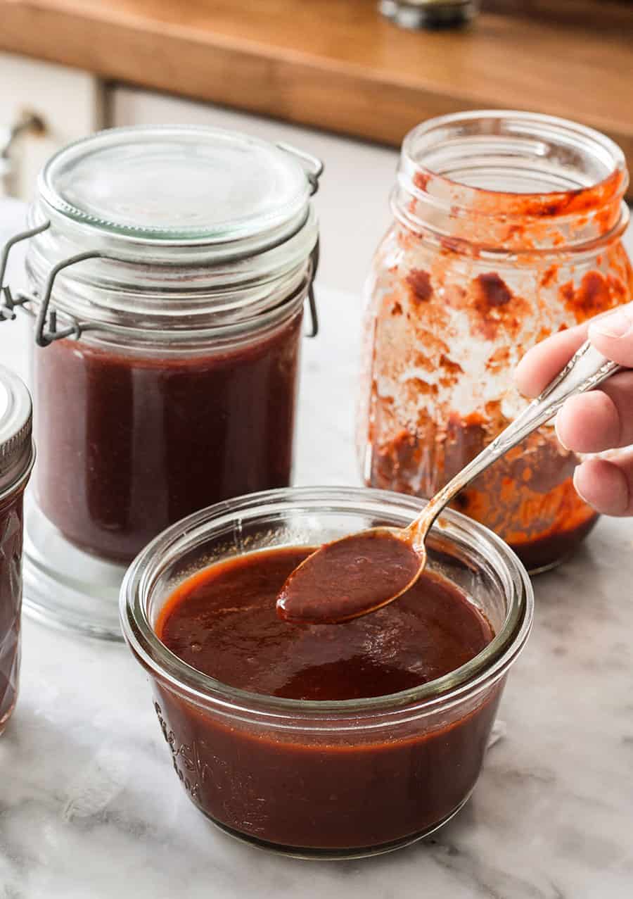 Salsa adobo en frascos y mostrando la textura con una cuchara.