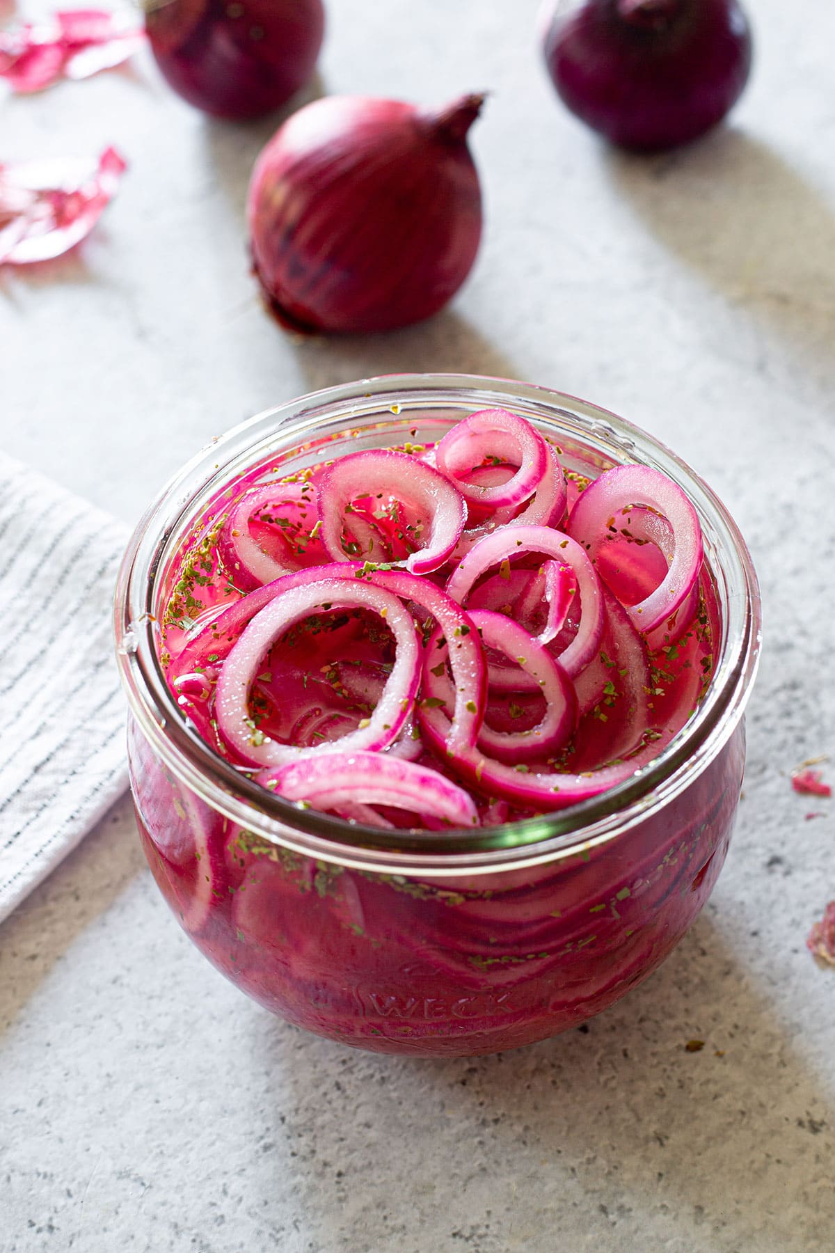 Mexican pickled onions in a jar and some raw red onions in the back.