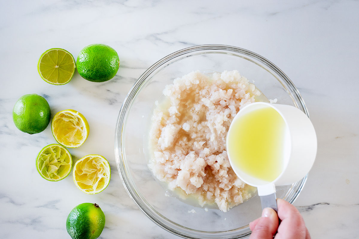 Addin lime juice to the fish meat in a bowl.