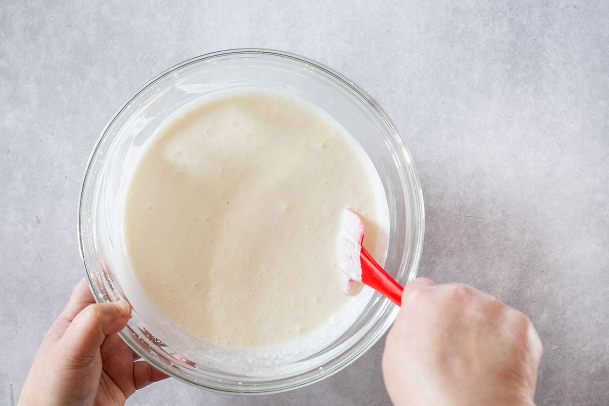 Mixing the cream mixture for fresas con crema in a bowl.