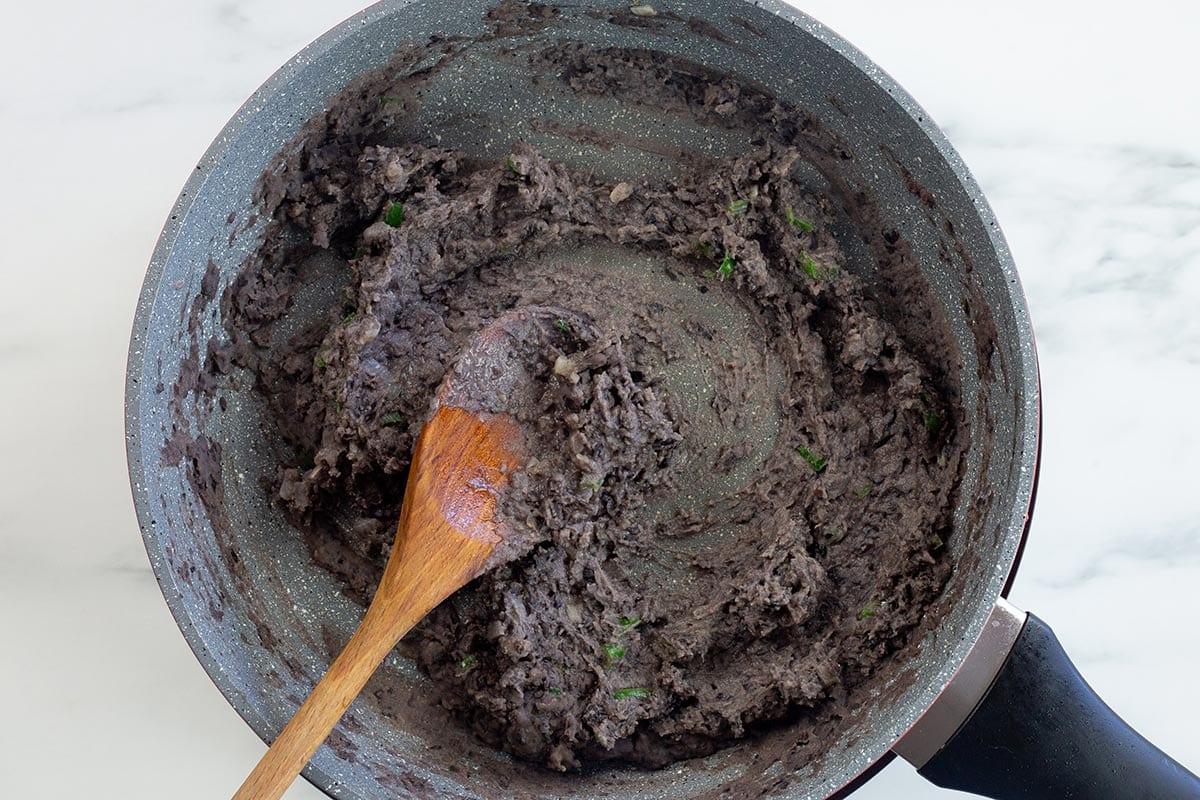 Refried black beans in a pan.