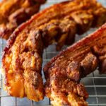Close-up of pork chicharrones placed on a cooling rack.
