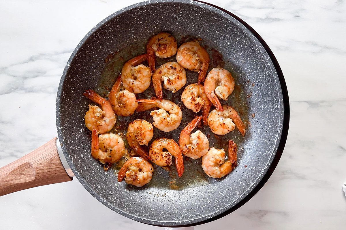Cooked shrimp with garlic on a pan.