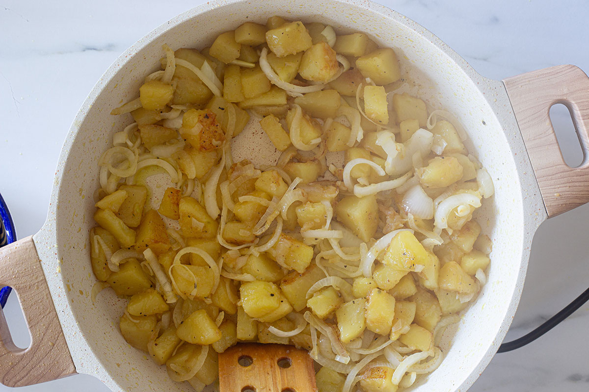 Potatoes and onions frying on a pan.