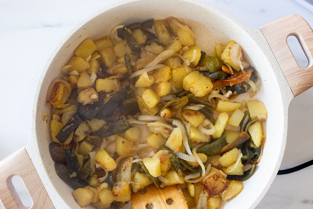 Rajas de chile poblano and potatoes cooking in a pan.