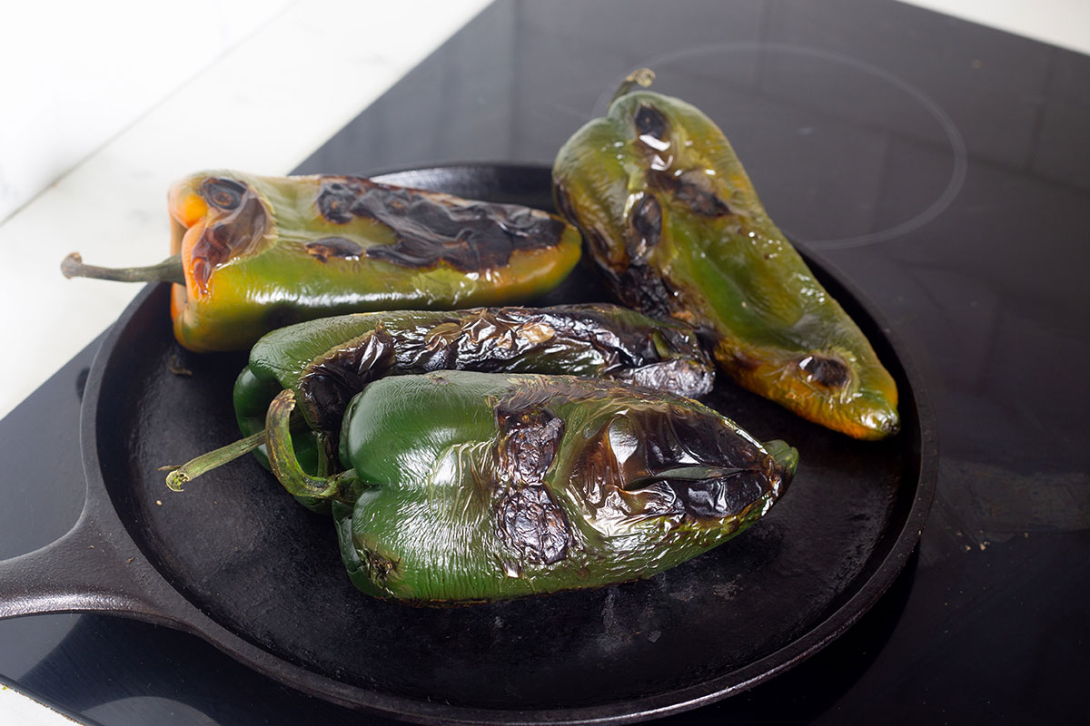 Charred chiles poblanos on a gridle.